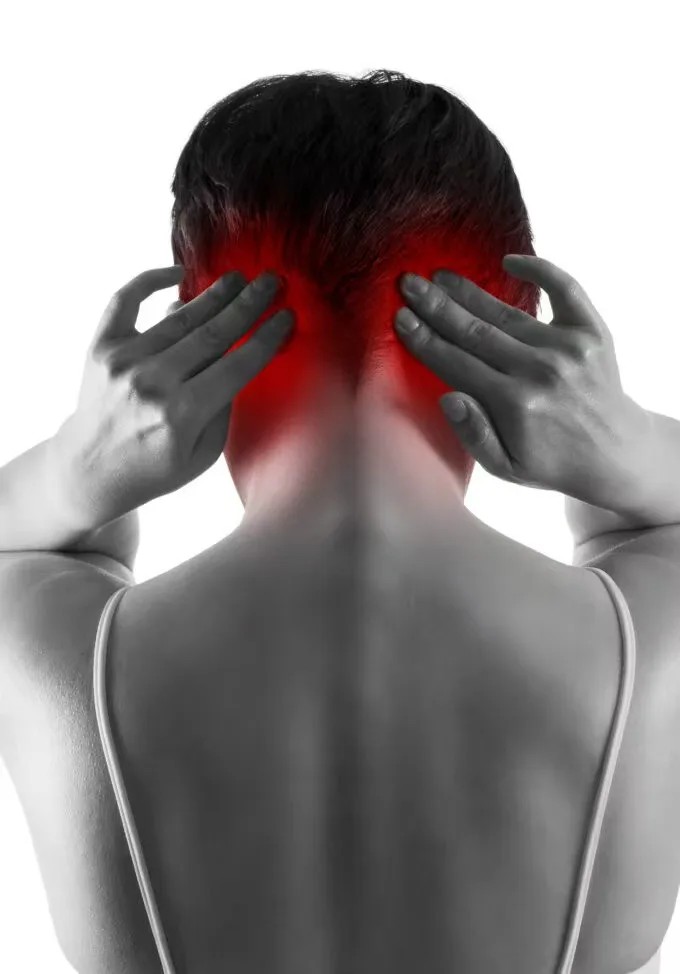 Person holding the back of the neck and lower skull, with the painful area highlighted in red